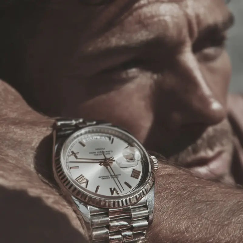 Man wearing VEXO Day Date watch with white ice dial and silver stainless steel bracelet under natural sunlight – luxury wristwatch lifestyle close-up