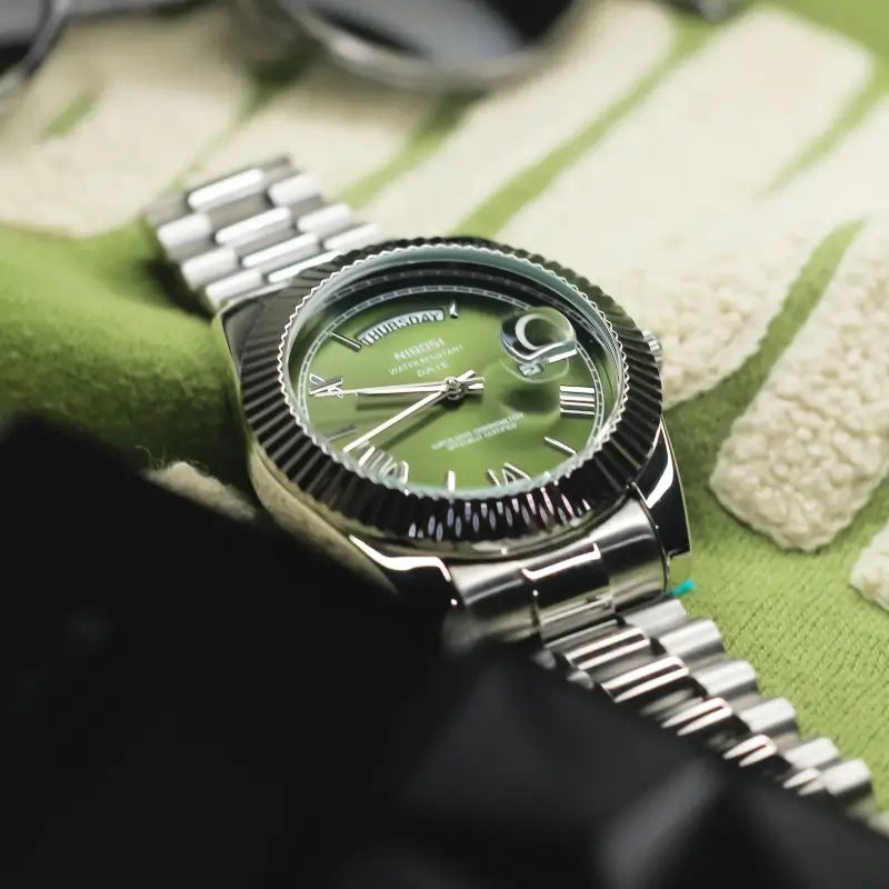 VEXO Day Date Olive luxury watch – green dial with Roman numerals, magnified date, and stainless steel bracelet in side view