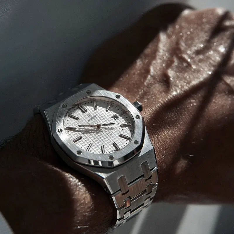 Close-up of the VEXO Kings Oak Ice watch on wrist, highlighting brushed stainless steel case and bracelet with a crisp white textured dial in direct sunlight