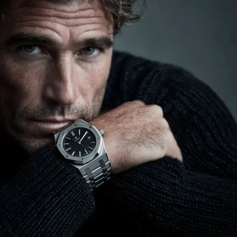 Man wearing the VEXO Kings Oak Iron watch with a dark knit sweater, showcasing the silver case and bracelet paired with a deep textured dial for a bold, masculine look